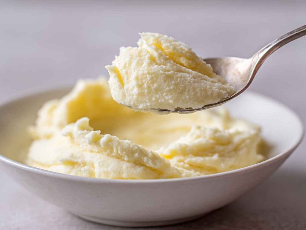 spoon lifting creamy mashed potatoes without milk showing smooth texture