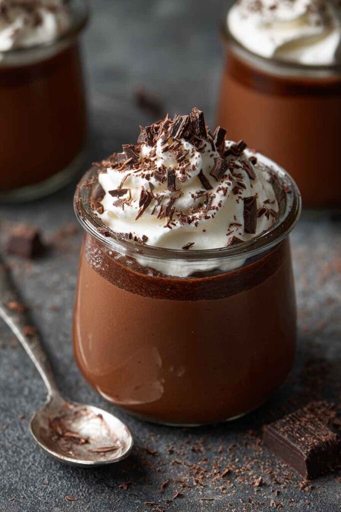 Chocolate mousse made with cottage cheese, served in a small glass jar with whipped cream and chocolate flakes on top