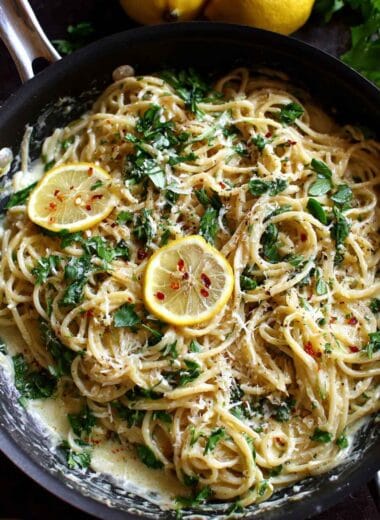 Creamy lemon parmesan pasta with fresh herbs and grated cheese in a pan
