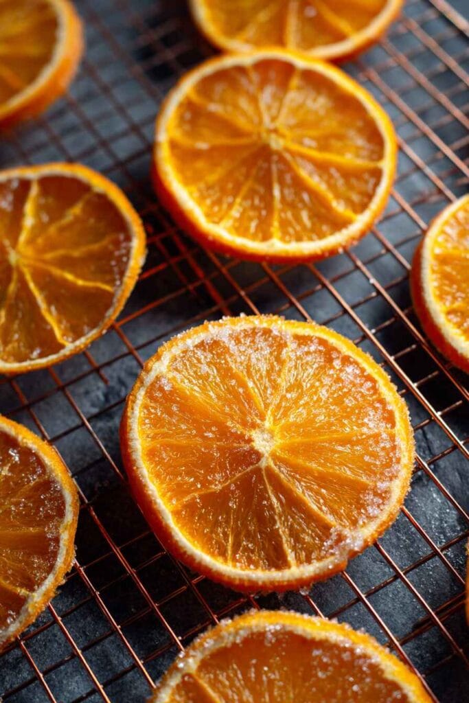 Candied orange slices drying on a wire rack after cooking