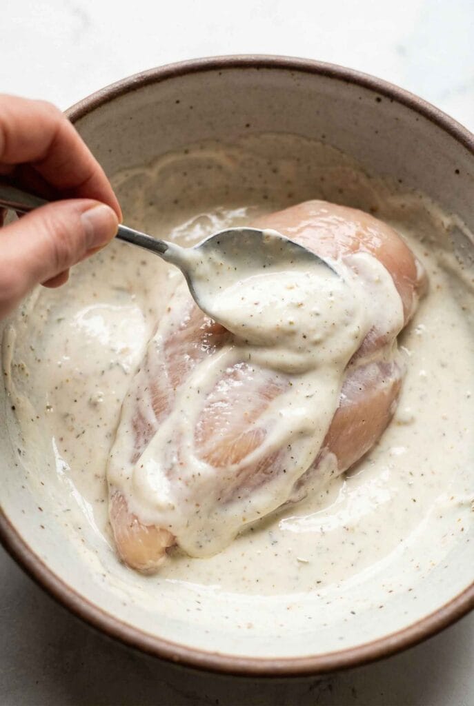 Chicken breast coated with yogurt marinade before cooking