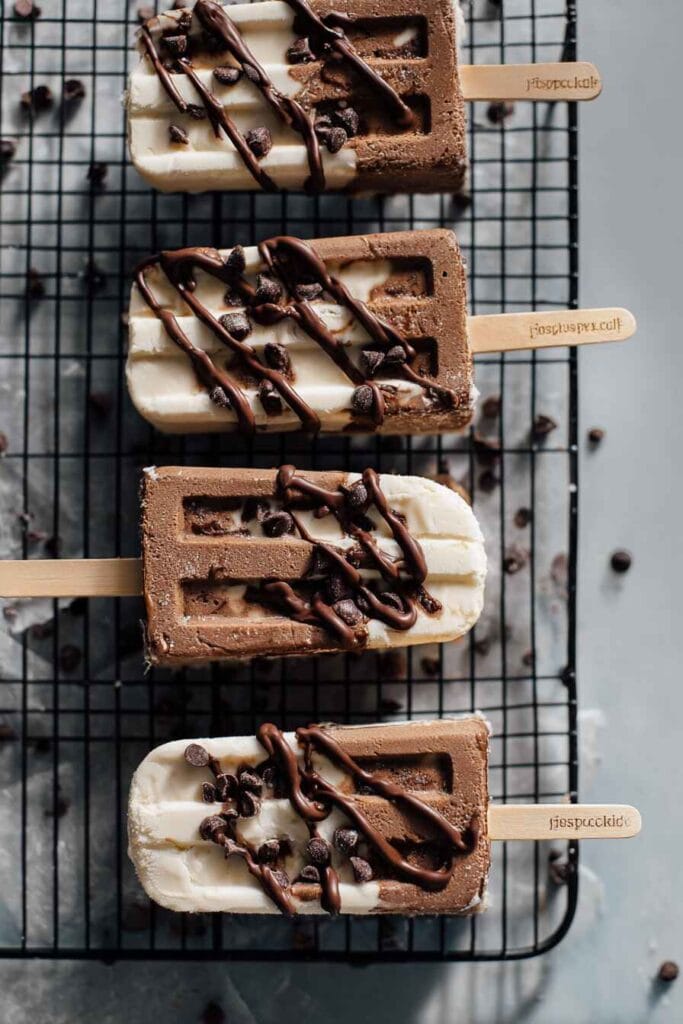 Greek yogurt ice cream bars with chocolate drizzle and chocolate chips on cooling rack top view