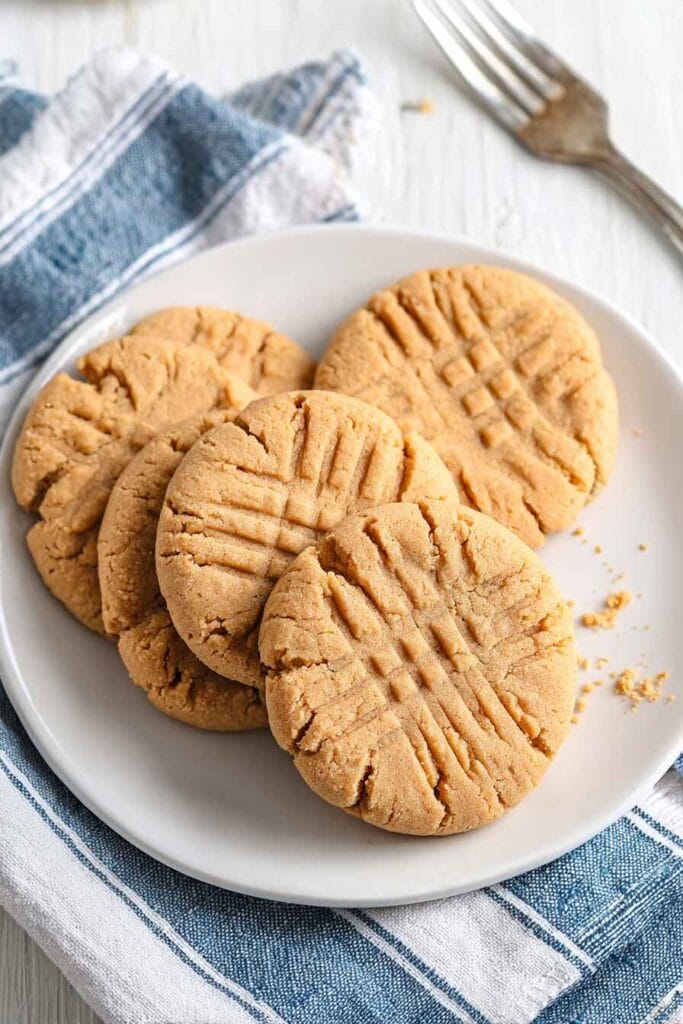 Easy peanut butter protein cookies served on a white plate with classic fork marks