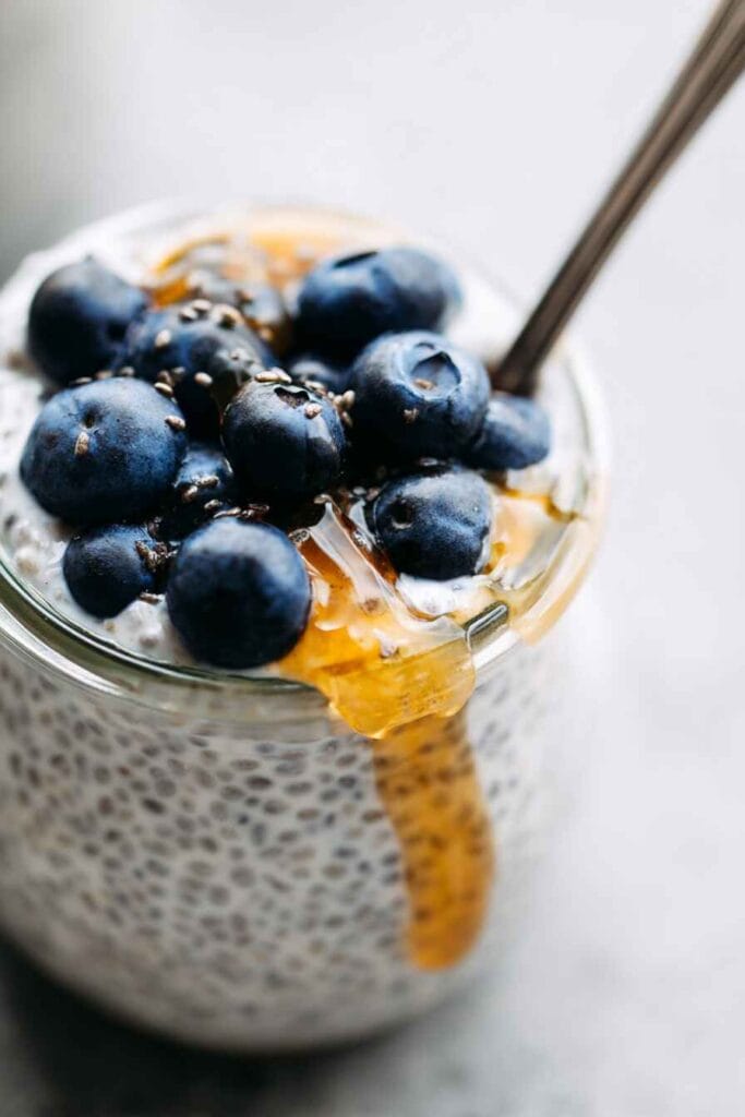 close-up of greek yogurt chia seed pudding topped with blueberries and honey