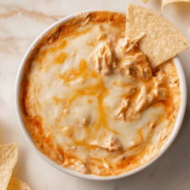 high protein buffalo chicken dip with melted cheese served with tortilla chips