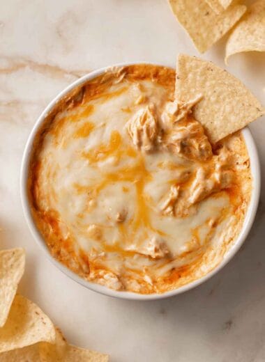high protein buffalo chicken dip with melted cheese served with tortilla chips