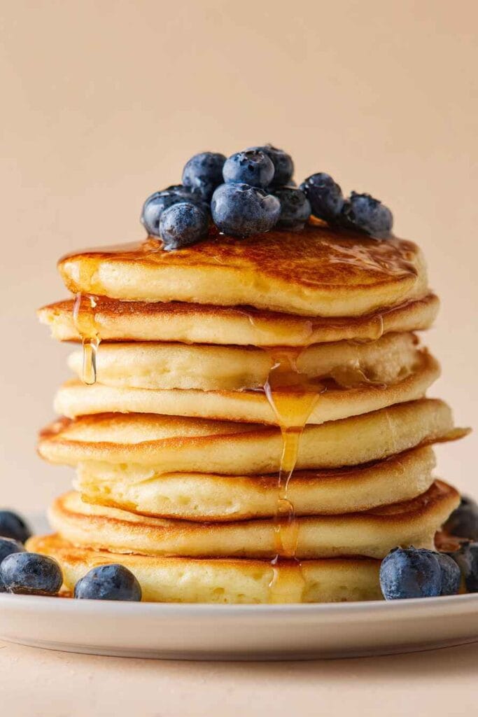 High protein cottage cheese pancakes with 22g protein, topped with blueberries and maple syrup