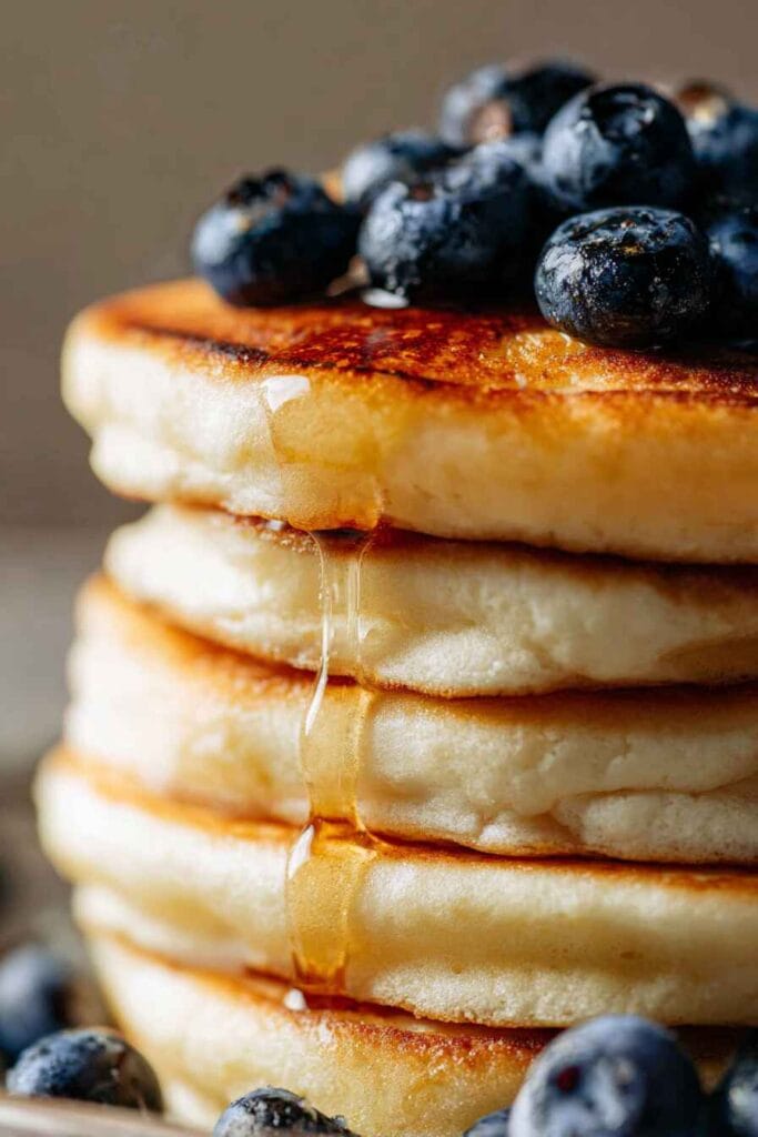 Close-up of cottage cheese pancakes with maple syrup and blueberries