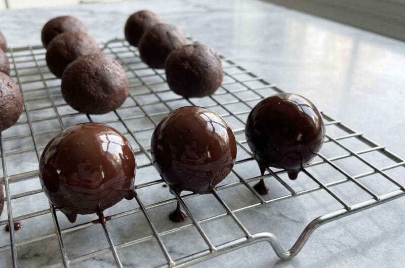 coating cottage cheese chocolate bites with melted chocolate on wire rack