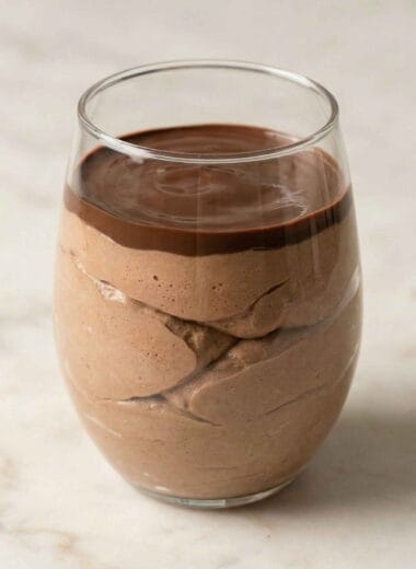 cottage cheese cheesecake no bake in a glass cup with smooth chocolate layer on top