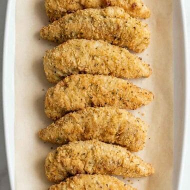 low calorie air fryer chicken tenders arranged neatly on parchment paper, golden crispy coating, light and healthy homemade recipe