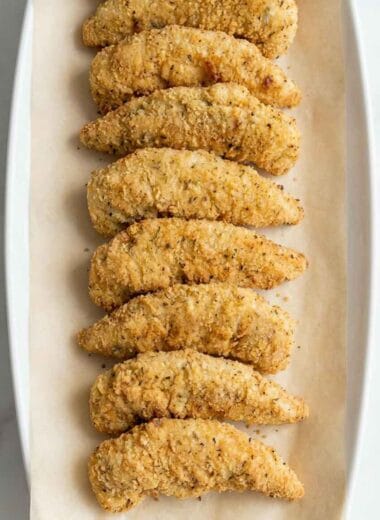 low calorie air fryer chicken tenders arranged neatly on parchment paper, golden crispy coating, light and healthy homemade recipe