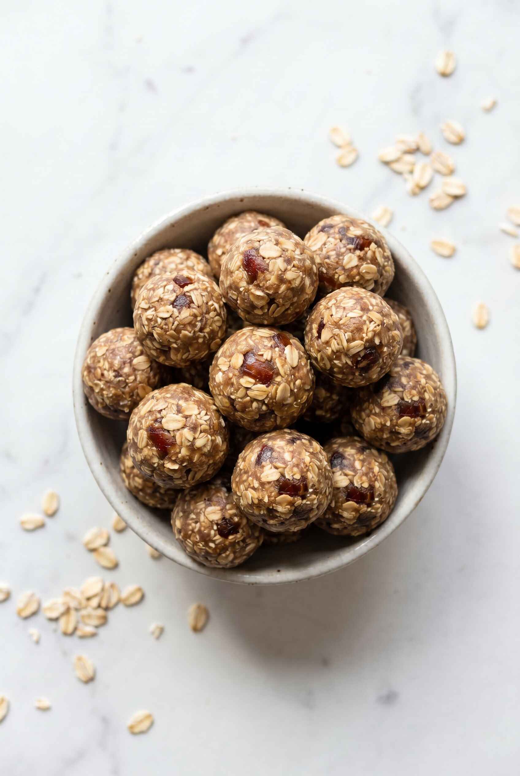 high protein date balls in a bowl with oats and visible date pieces