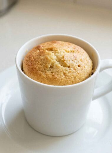 High protein vanilla mug cake in a white mug, soft fluffy texture, easy 3 ingredient recipe