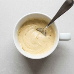 Smooth mug cake batter being mixed in a mug with a spoon